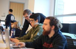 Screenwriting students working on laptops in a classroom